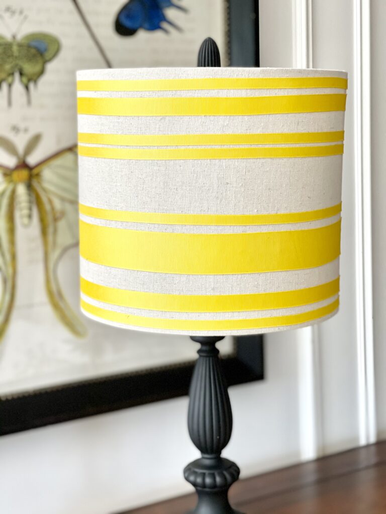 A DIY yellow ribbon lampshade for my Primary Bedroom desk. A custom lampshade made using ribbon, 3M ATG Transfer Tape to apply the ribbon, and painters tape as guides for making pereclty straight and even lines.