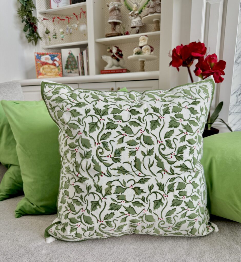 Holly & Red Berry block printed Christmas Napkins are transformed into gorgeous custom holiday pillows. Stacked among more pear green velvet pillows.