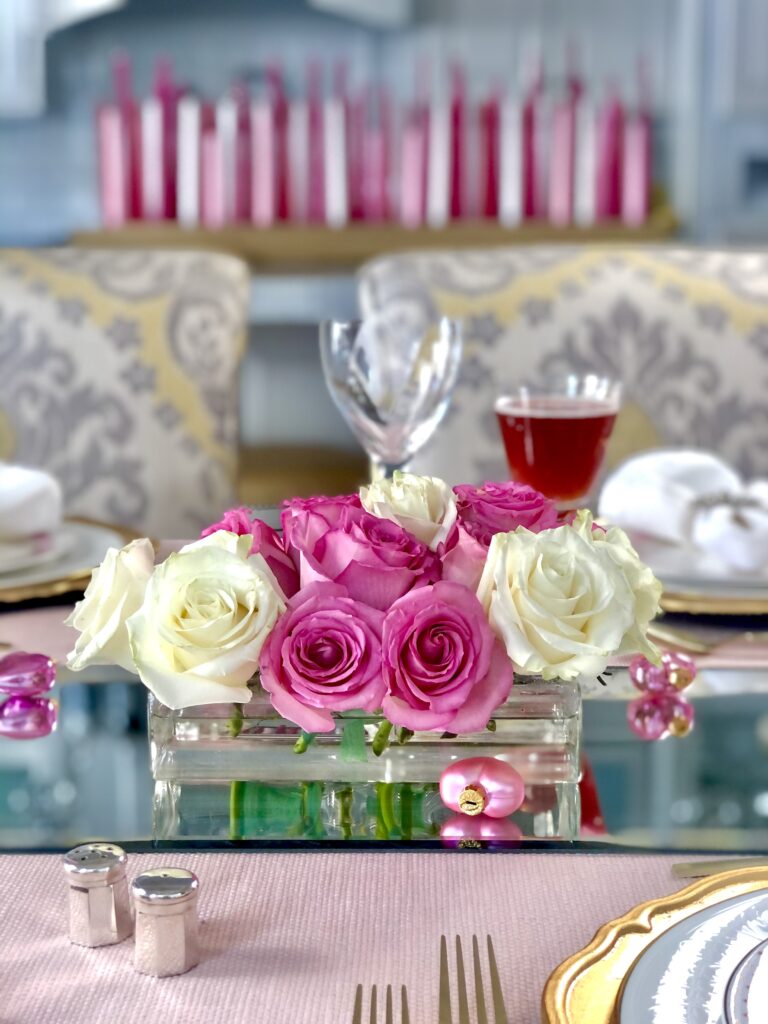 Pink & White roses mounded into a low glass container and set on a mirrored glass tablerunner.