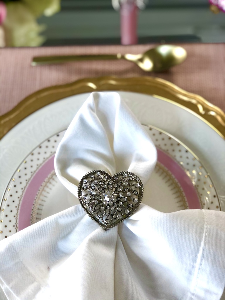 Valentine table set with a napkin in a sparkling heart shaped ring. 