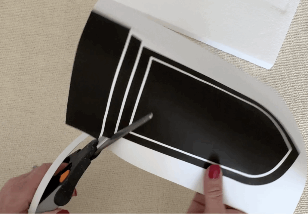 Cutting out a paper headstone to use as a template to create foam headstones.